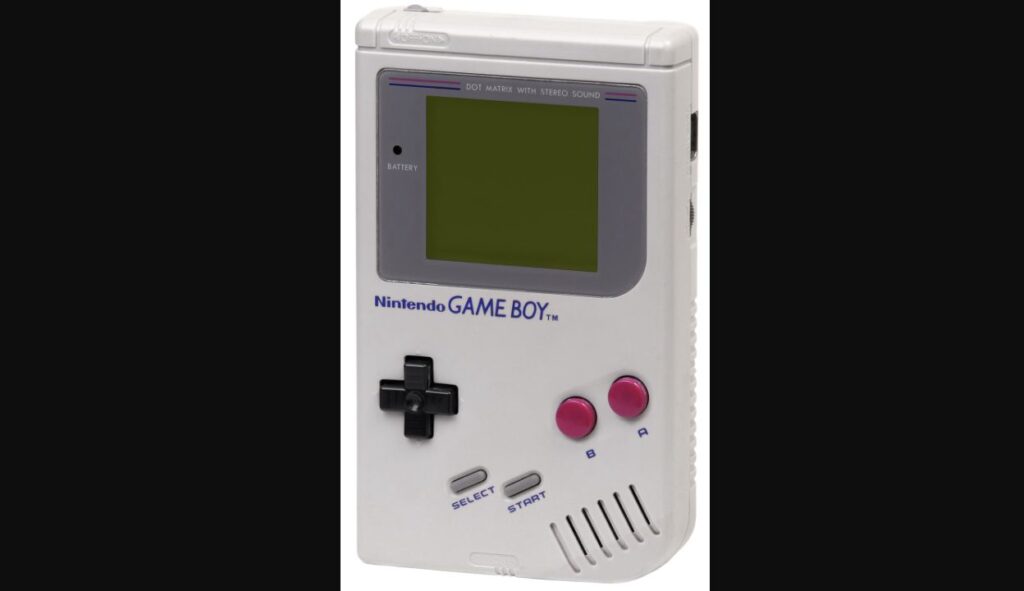 白い本体に十字キーと赤紫のボタンを備えた初代ゲームボーイ。画面にゲーム映像は表示されていない