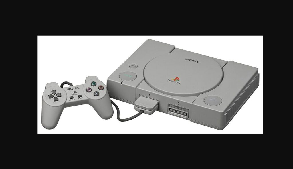 灰色の初代プレイステーション本体と、接続されたコントローラーとメモリーカード
